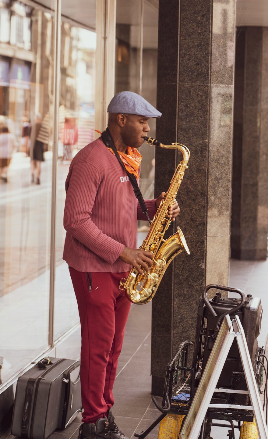 Un musicien de rue joue du saxophone sur le trottoir de la ville.